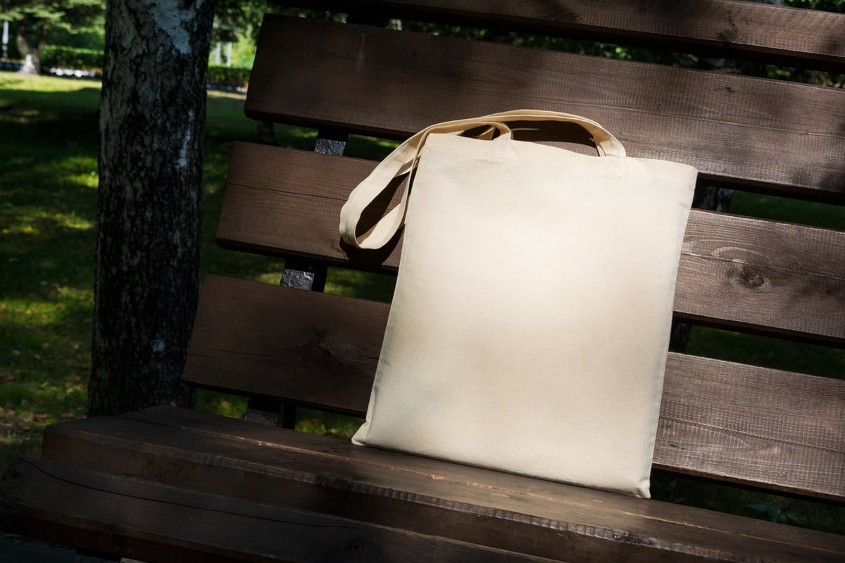 Canvas tote bag in the shade of trees mockup